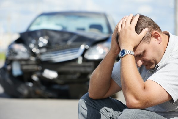 man holding his hands in front of a car accident